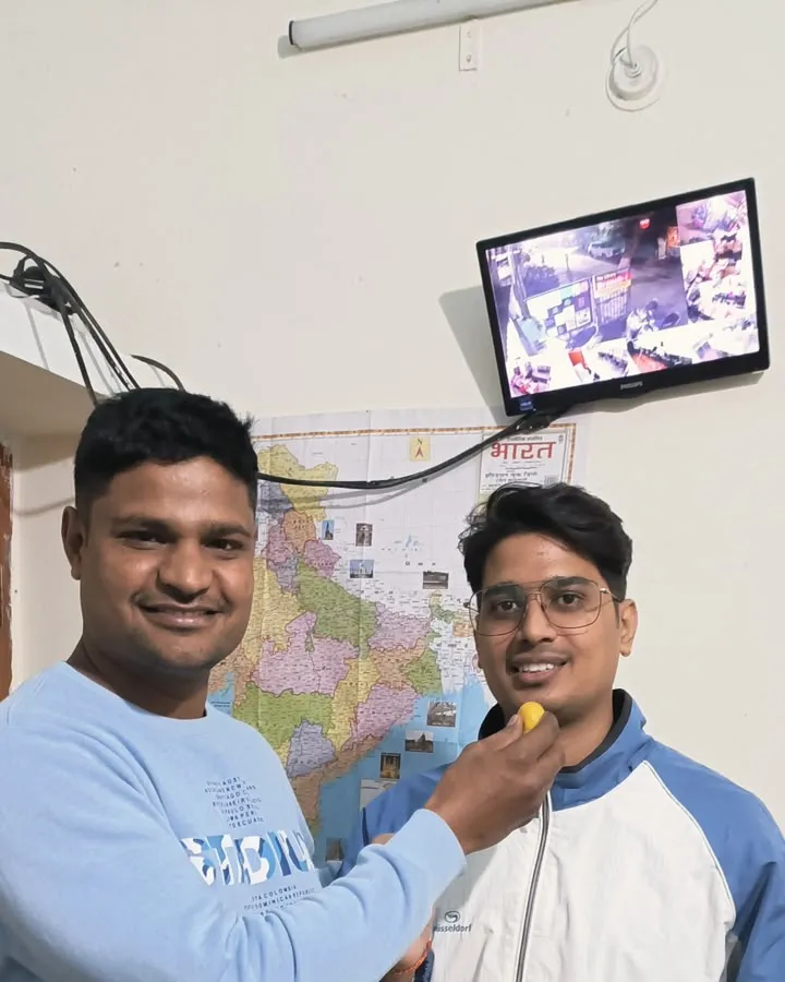 Aaditya Singh being fed a sweet at the institute, a map of India on the wall behind, after his CBI Inspector selection