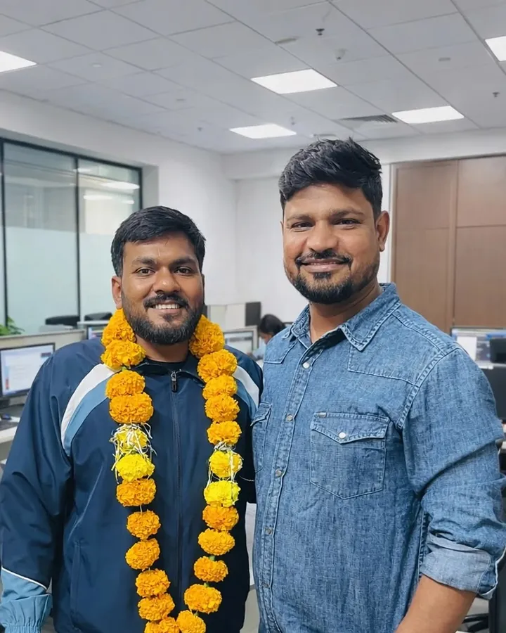 Sonu Kumar wearing a marigold garland, standing with a member of the Vivekananda team after his ALP selection