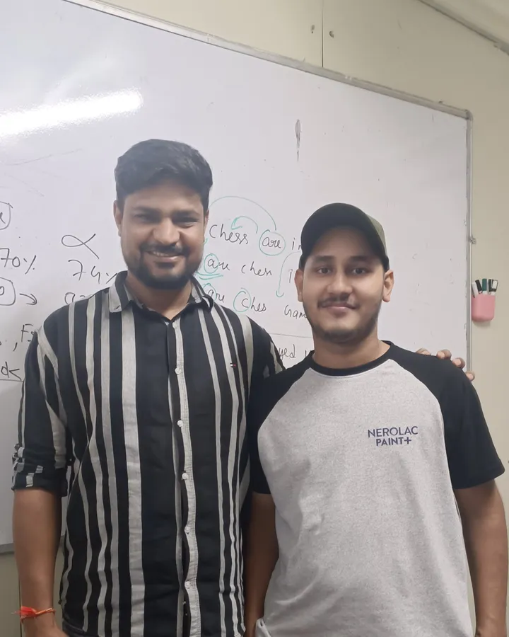 Gaurav Singh standing with a member of the Vivekananda team in front of a whiteboard after his NEET result
