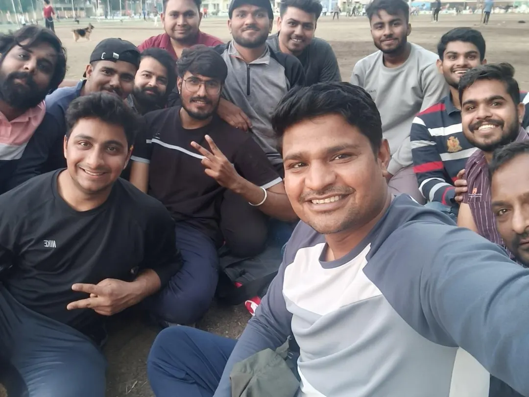 A wide outdoor selfie of a large group of students crowded in around the camera